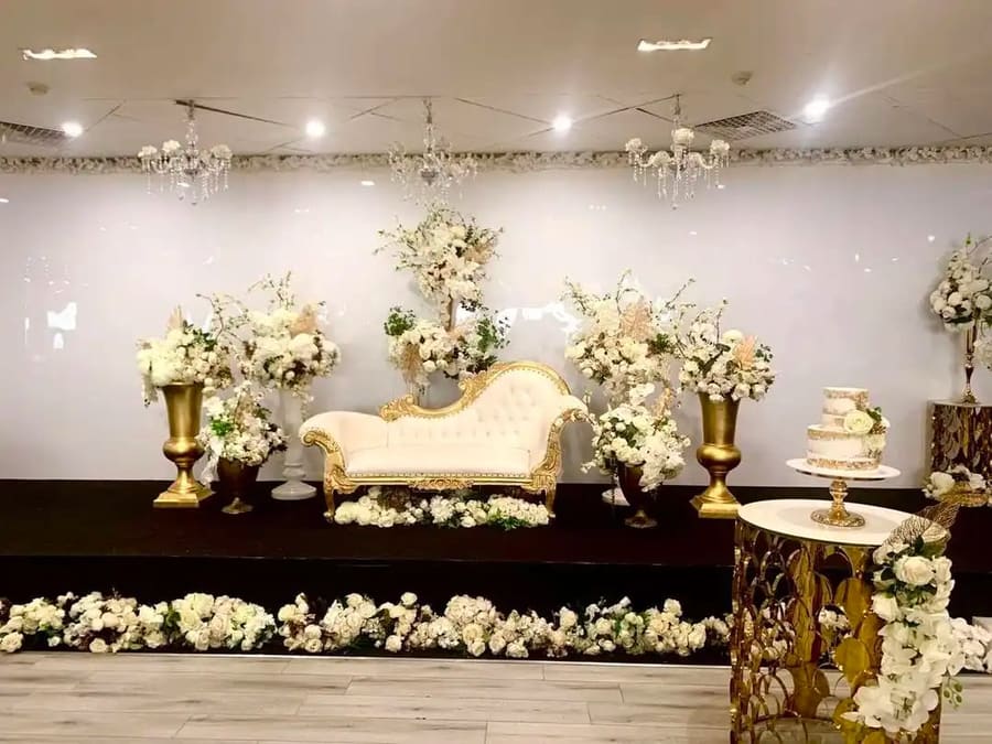 Gold lounge and white florals on the stage