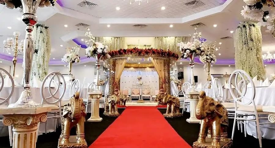 Mandap with gold elephants along a red carpet