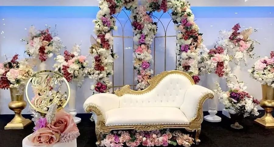 Gold-trimmed lounge framed by a floral arch