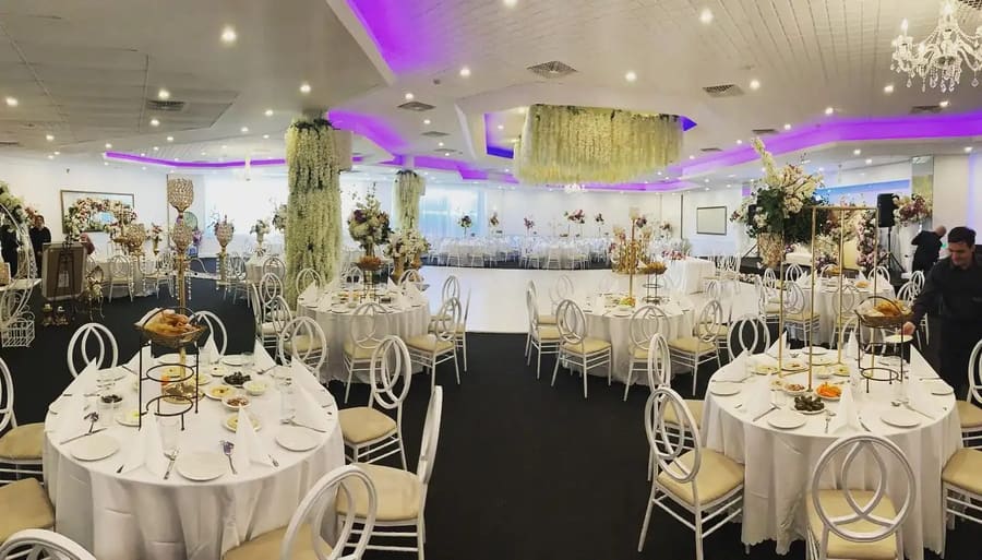 Room set with round tables beneath a hanging floral ceiling