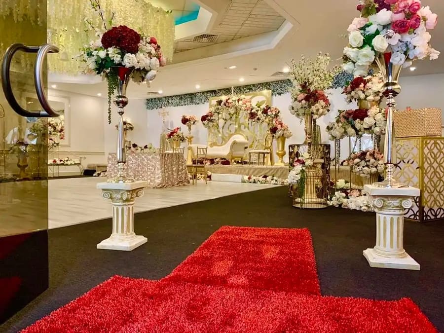 Red carpet entrance lined with florals and columns
