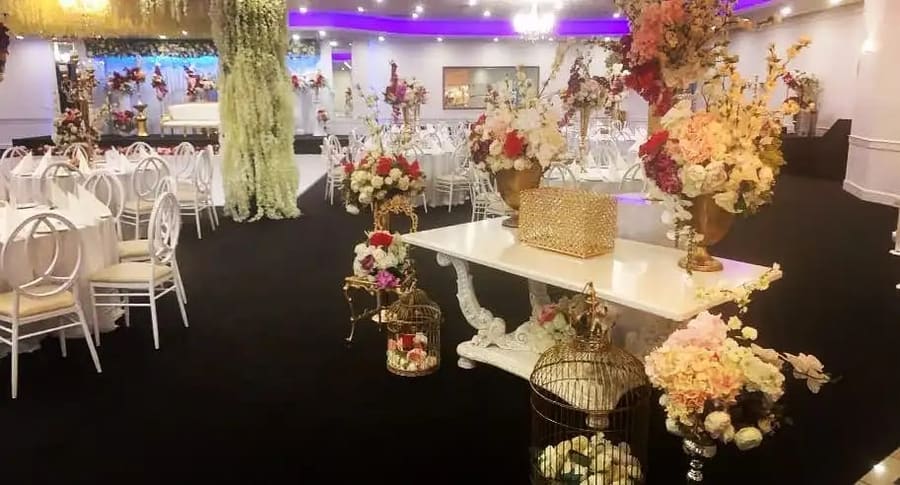 Gift table with birdcages and florals, round tables set behind