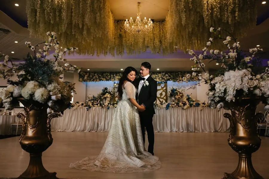 Bride and groom on the dance floor under a hanging floral ceiling