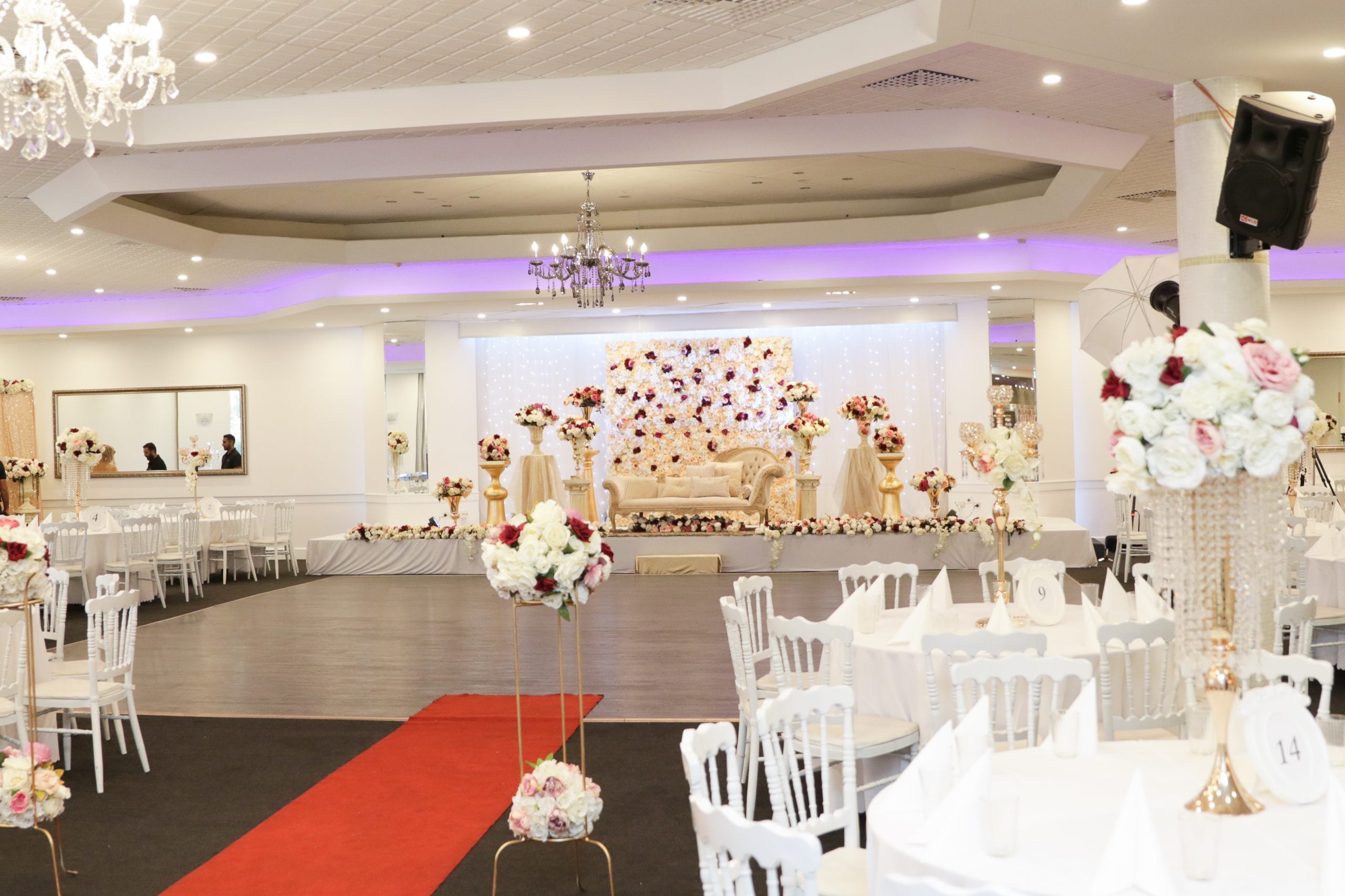 The function room with chandeliers and a red carpet aisle