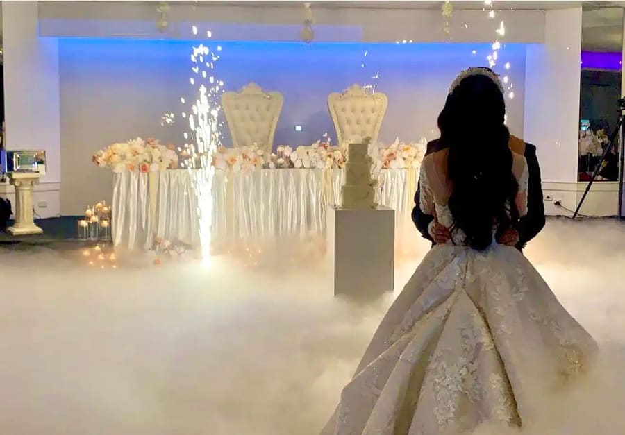 Bride facing the head table as cold sparklers fire