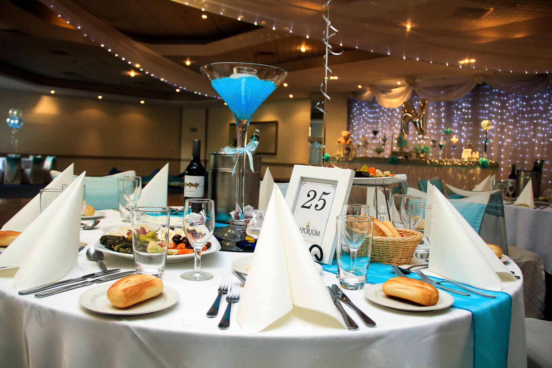 Martini-glass centrepiece and table settings under fairy lights