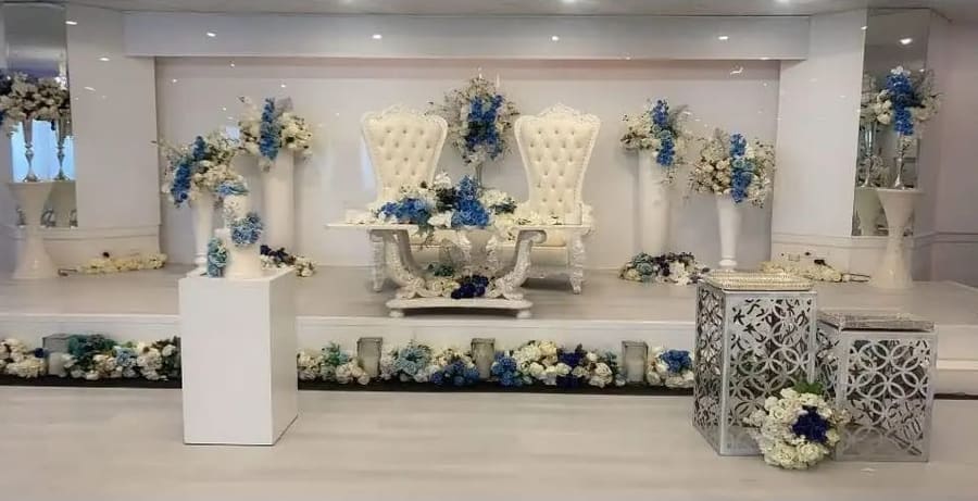 Throne chairs and blue and white florals on the stage