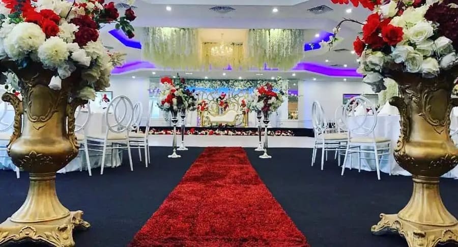 Red carpet aisle between gold urns to the stage