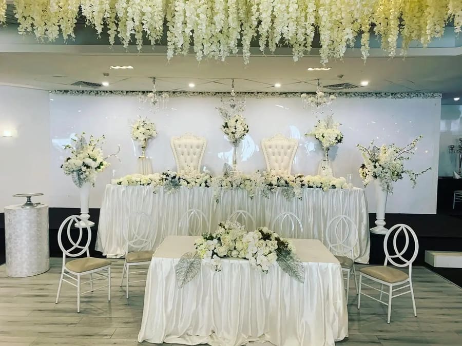 Head table and a dressed table under a hanging floral ceiling