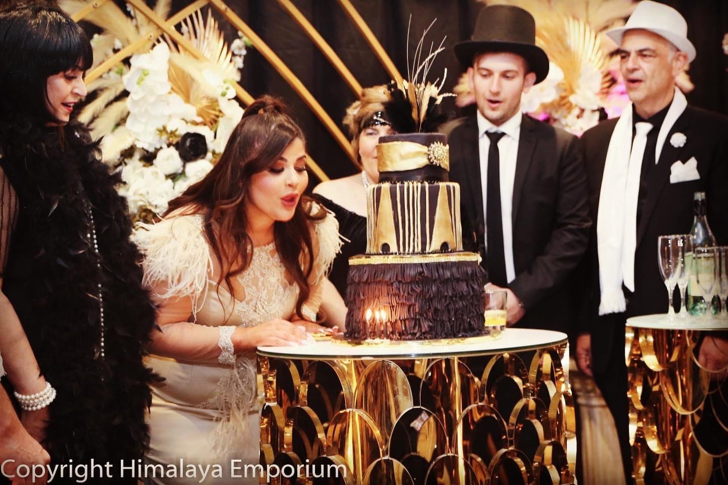 Guests in 1920s costume around a celebration cake