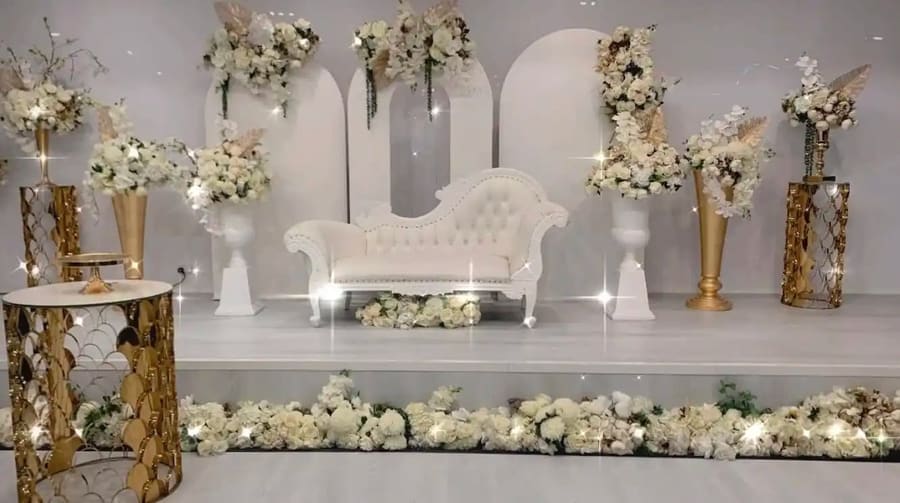 White lounge in front of arched panels and florals